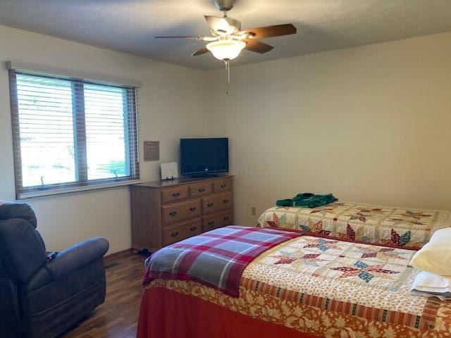 bedroom featuring ceiling fan and dark wood-type flooring