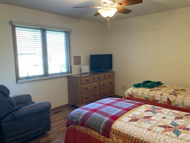 bedroom with ceiling fan and dark wood-type flooring