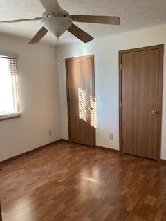 unfurnished bedroom featuring ceiling fan and dark hardwood / wood-style floors