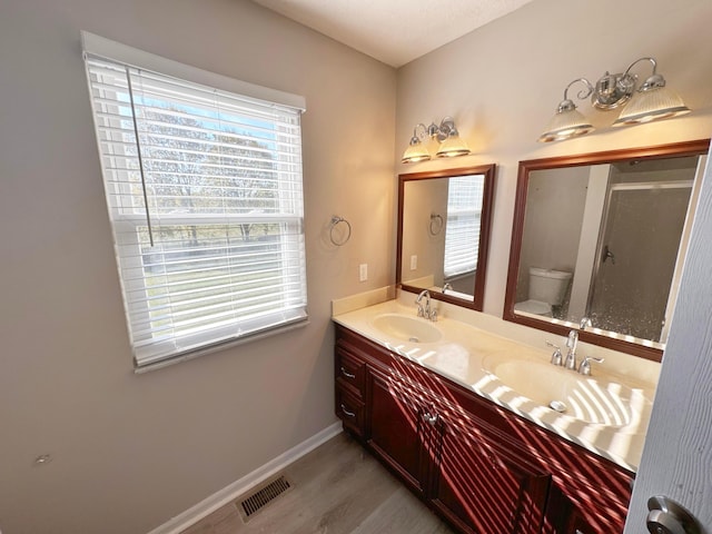 bathroom with hardwood / wood-style flooring, vanity, toilet, and a wealth of natural light