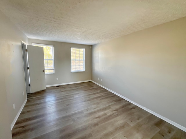 spare room featuring hardwood / wood-style floors and a textured ceiling