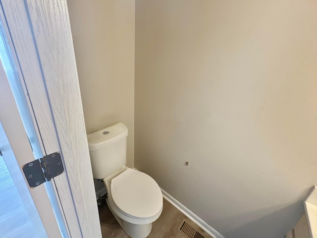 bathroom with hardwood / wood-style flooring and toilet