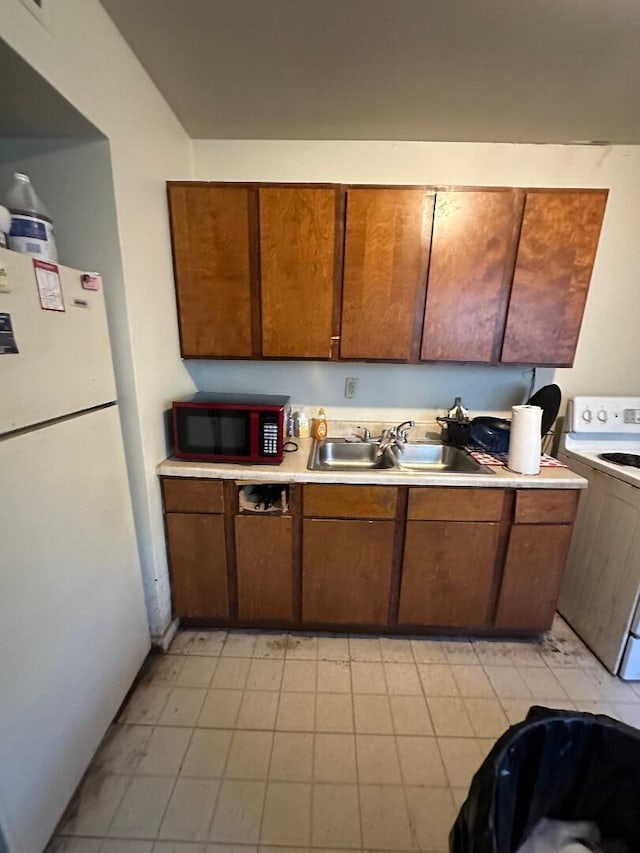 kitchen featuring white appliances and sink