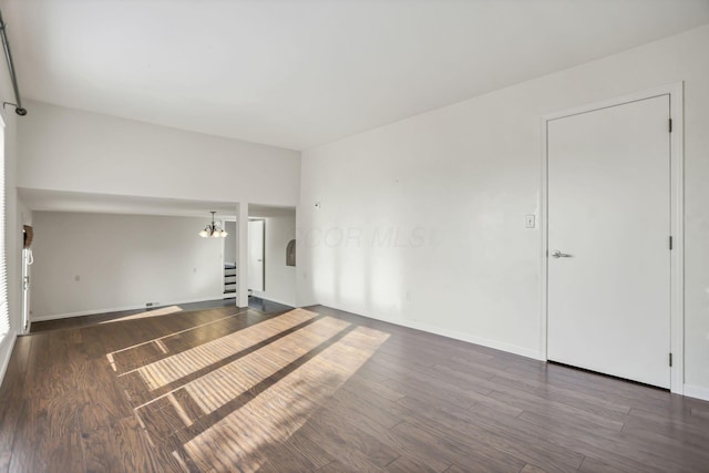 unfurnished living room with a chandelier and dark hardwood / wood-style floors