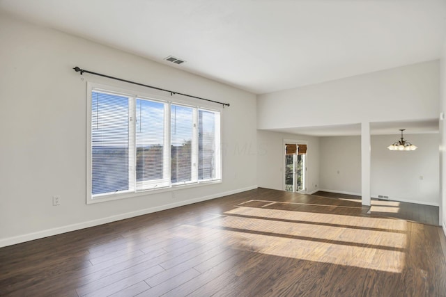 unfurnished living room featuring dark hardwood / wood-style flooring and a chandelier