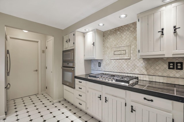 kitchen featuring stainless steel appliances, white cabinetry, and tasteful backsplash