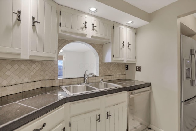 kitchen featuring white cabinets, sink, stainless steel dishwasher, decorative backsplash, and fridge with ice dispenser