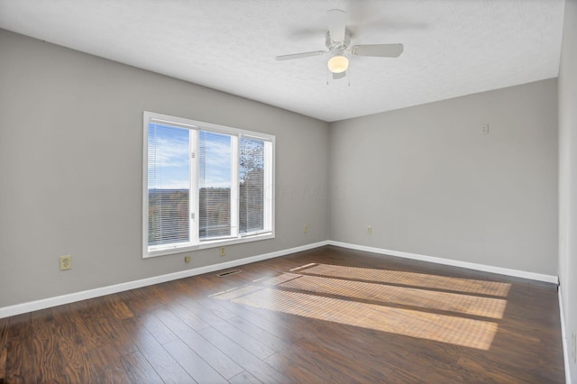 empty room with a textured ceiling, ceiling fan, and dark hardwood / wood-style floors