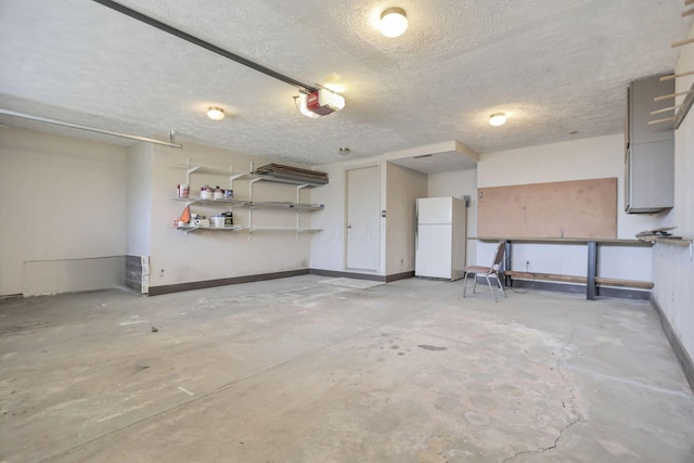 garage featuring white fridge and a garage door opener