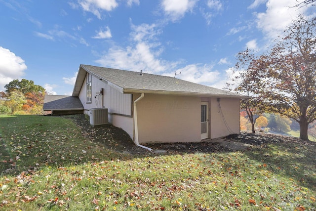 view of side of home with a lawn and central AC unit