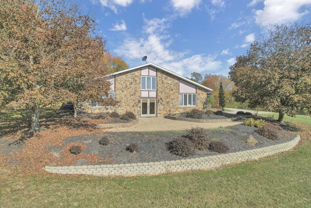 back of property with a yard and french doors