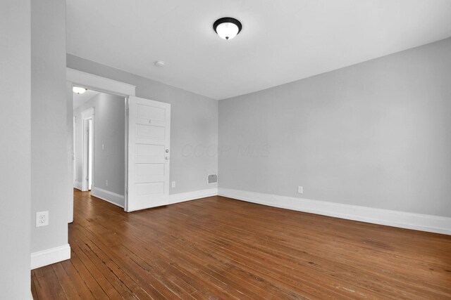 spare room with dark hardwood / wood-style floors