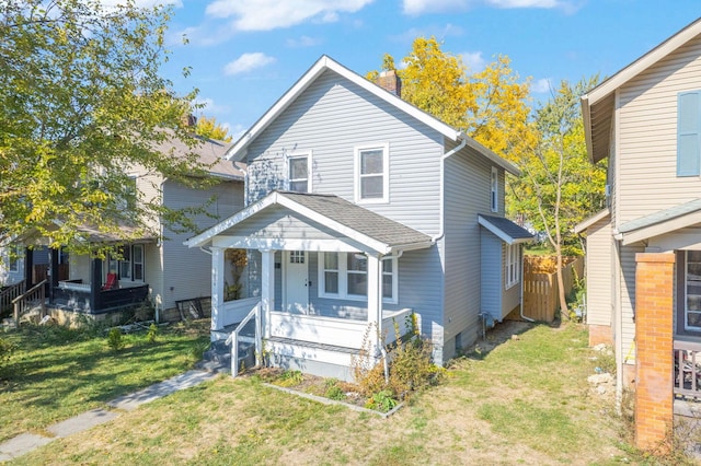 front of property with covered porch and a front yard