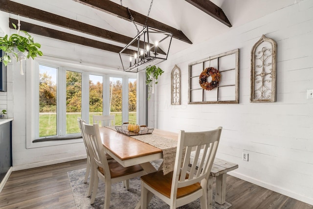 dining room featuring lofted ceiling with beams, dark wood-type flooring, and an inviting chandelier