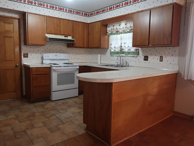 kitchen with white range with electric stovetop, kitchen peninsula, and sink