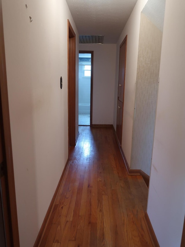 hall featuring hardwood / wood-style floors and a textured ceiling