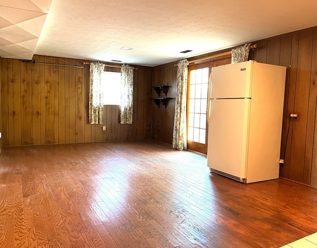 unfurnished room with wood walls and wood-type flooring