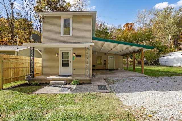 front of property with a carport, a porch, and a front yard