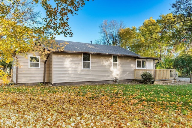 back of house with a deck and a yard