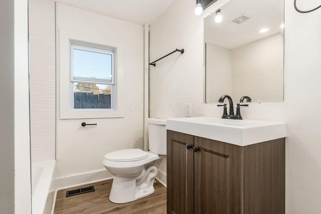 bathroom with vanity, toilet, and wood-type flooring