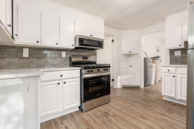 kitchen with stainless steel appliances, a textured ceiling, decorative backsplash, white cabinets, and light wood-type flooring