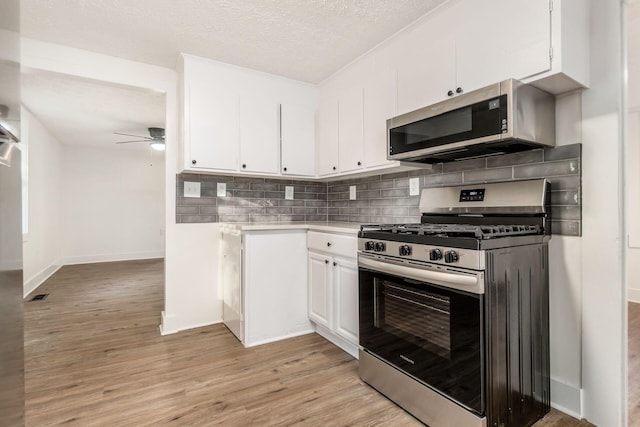 kitchen featuring white cabinetry, ceiling fan, tasteful backsplash, appliances with stainless steel finishes, and light wood-type flooring