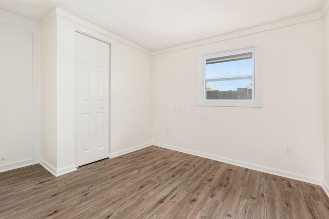 empty room featuring dark hardwood / wood-style floors and a textured ceiling