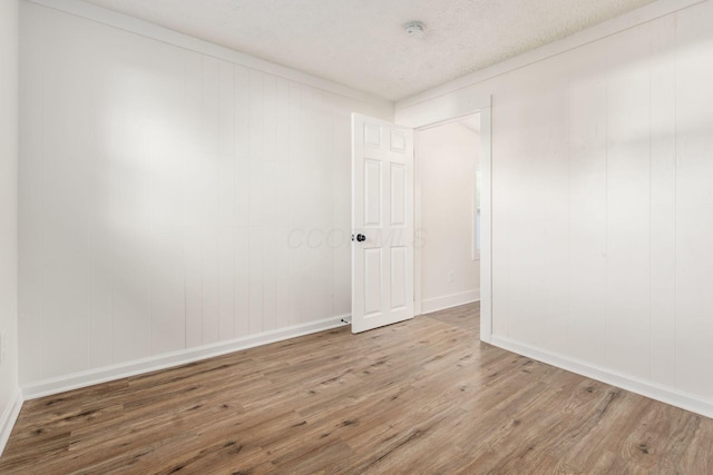 unfurnished room with a textured ceiling and hardwood / wood-style flooring