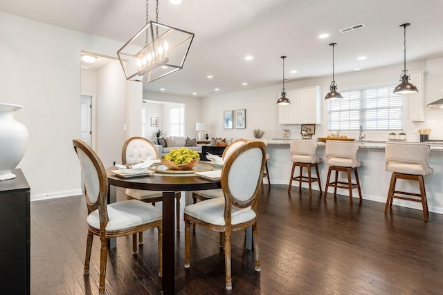 dining area with dark hardwood / wood-style flooring and a chandelier