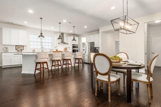 dining room featuring dark hardwood / wood-style flooring, sink, and an inviting chandelier