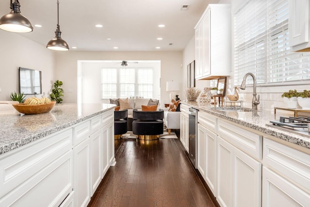 kitchen featuring ceiling fan, sink, dark hardwood / wood-style flooring, pendant lighting, and white cabinets