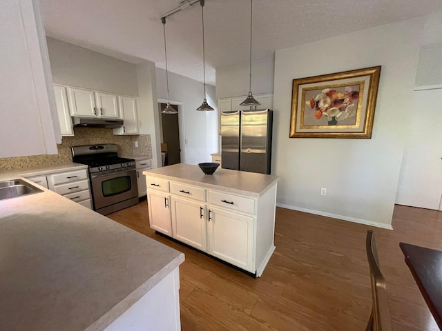 kitchen featuring white cabinets, hanging light fixtures, dark hardwood / wood-style floors, decorative backsplash, and stainless steel appliances