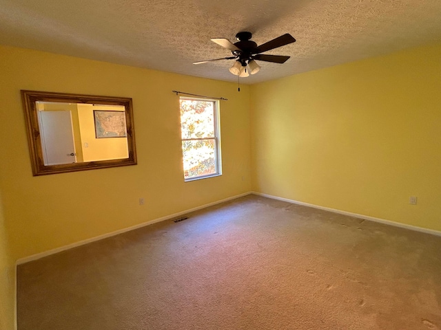 carpeted spare room featuring ceiling fan and a textured ceiling