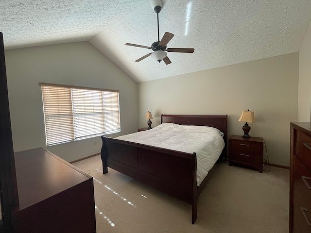 carpeted bedroom with a textured ceiling, ceiling fan, and vaulted ceiling