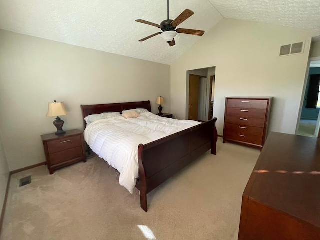 bedroom with ceiling fan, lofted ceiling, a textured ceiling, and light carpet