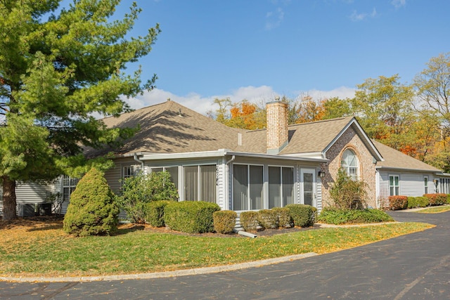 view of side of property featuring a sunroom and a yard