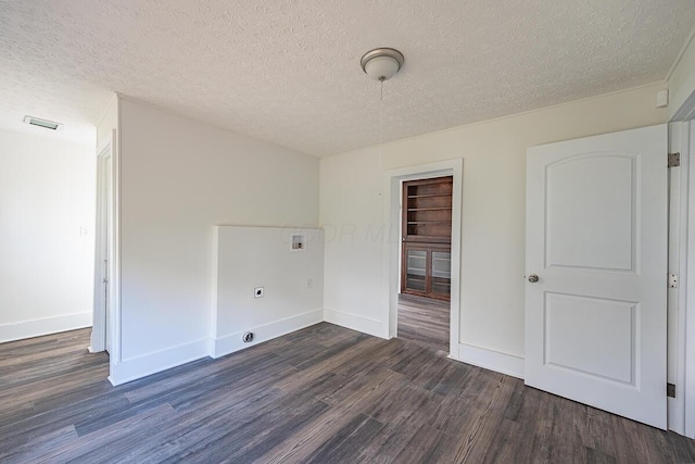 empty room with dark wood-type flooring and a textured ceiling