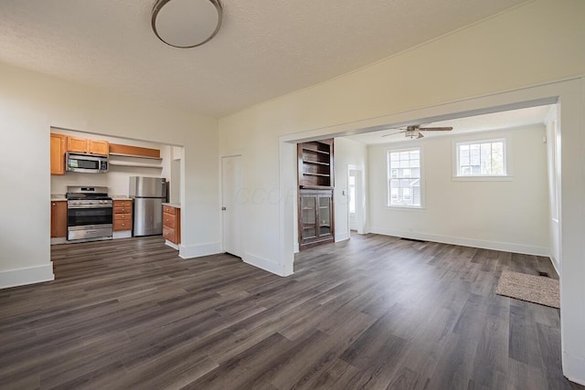 unfurnished living room with dark hardwood / wood-style floors, ceiling fan, and a textured ceiling