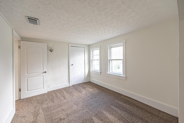 unfurnished bedroom with a textured ceiling and carpet floors