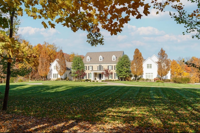 cape cod home featuring a front yard