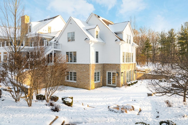 view of snow covered back of property