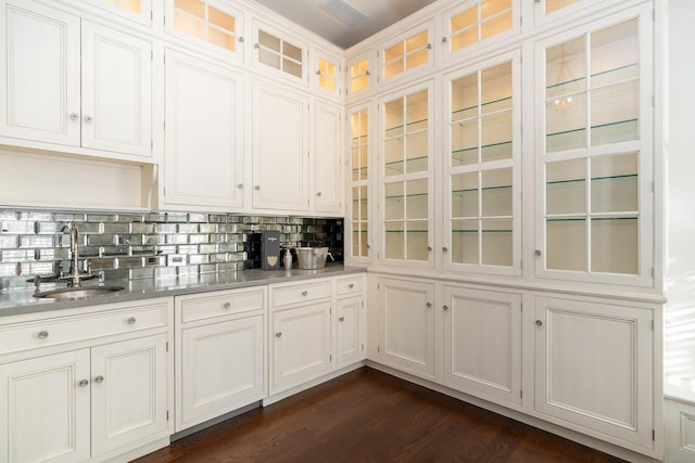 kitchen featuring sink, white cabinets, dark wood-type flooring, and decorative backsplash