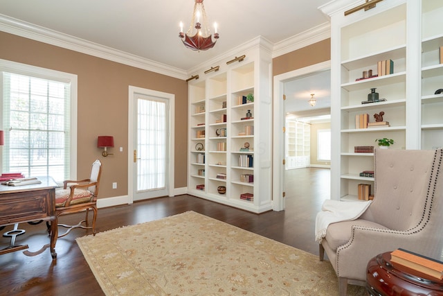 sitting room with dark wood-type flooring, built in shelves, ornamental molding, and a chandelier