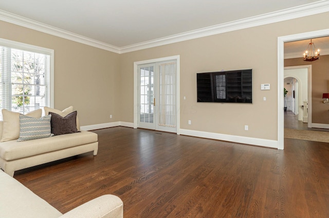 living room featuring a notable chandelier, ornamental molding, and dark hardwood / wood-style flooring