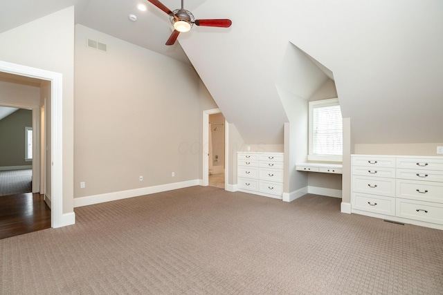 additional living space with carpet floors, lofted ceiling, and built in desk