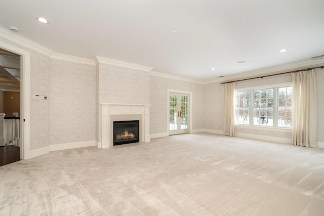 unfurnished living room featuring light colored carpet, ornamental molding, and french doors