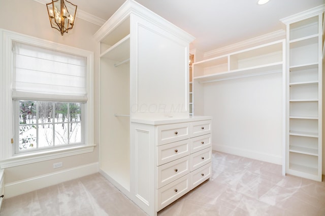 walk in closet featuring light colored carpet and an inviting chandelier