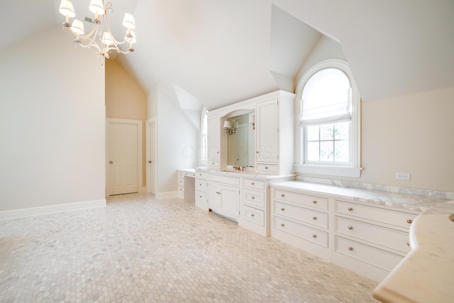 bathroom featuring vanity, lofted ceiling, and an inviting chandelier