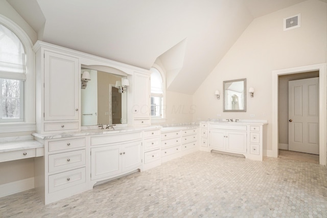 bathroom featuring vanity and lofted ceiling