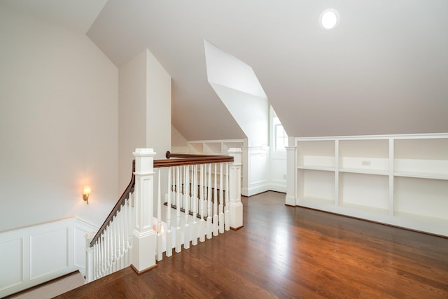 additional living space featuring dark wood-type flooring and lofted ceiling